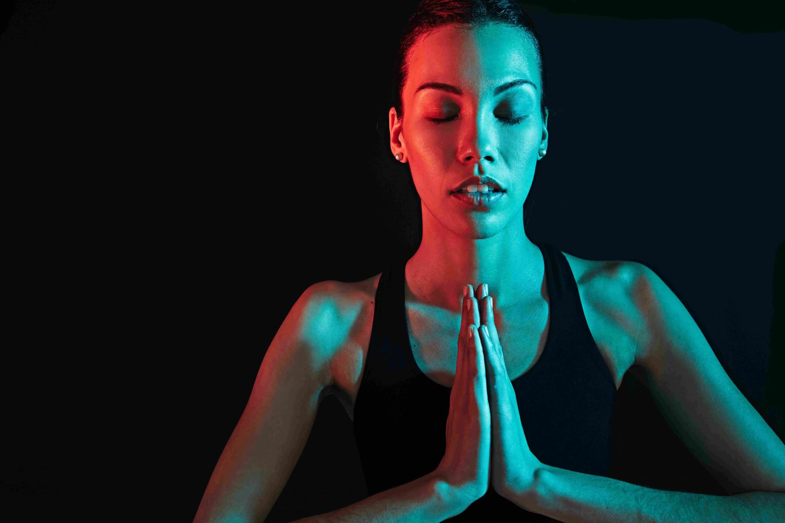 Woman meditating with closed eyes in soft light
